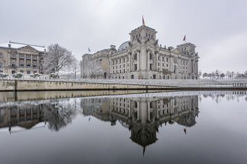 Fototapeta na wymiar Reichstag building (Bundestag) and with reflection in river Spree in Winter, Berlin government district, Germany, Europe