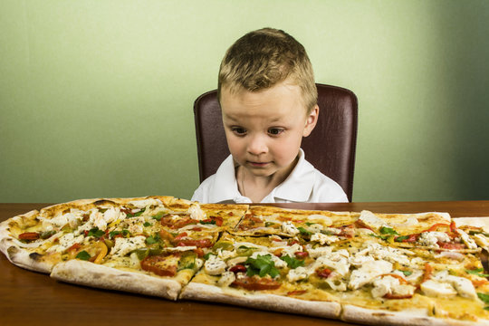 boy eating a large pizza
