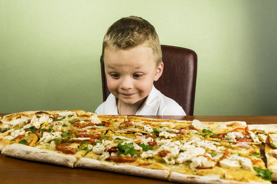 boy eating a large pizza