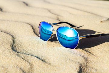 Fototapeta na wymiar Sunglasses on the sand in the desert.