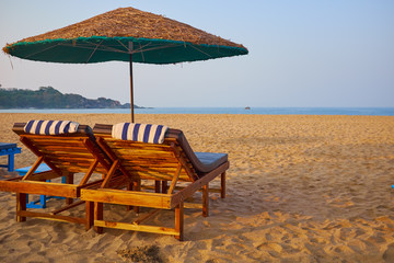 empty beach chairs on a tropical beach
