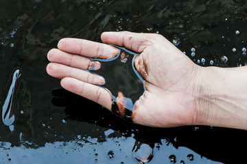 crude oil in hand due to crude oil leak.crude oil low price concept.