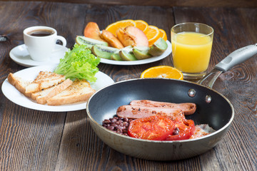 Full English breakfast with sausage, baked tomato, beans and toa