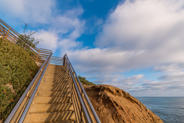 Staircase going up a cliff with a cloudy sky background at Sunset Cliffs in San Diego, California.  