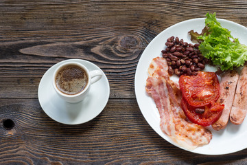 American breakfast, bacon, sausage, tomato, beans and salad