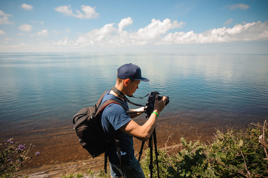 man taking photo, photographing lake