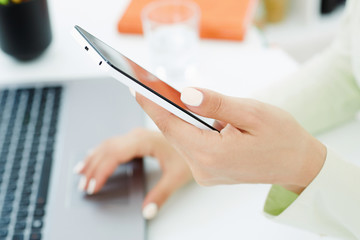 Girl holding smart phone. Stylish modern office workplace on a background.