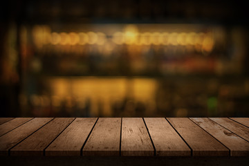 wooden table with a view of blurred beverages bar backdrop - obrazy, fototapety, plakaty