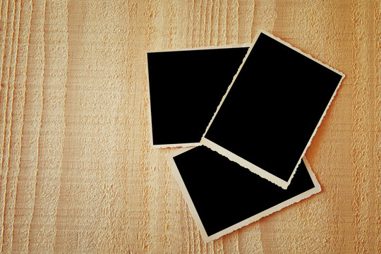 top view of blank photos frame on wooden background