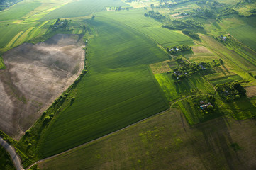 Aerial view on green and yellow parts of fields and countryside