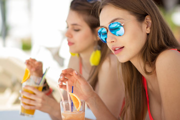 two attractive young women drinking cocktails