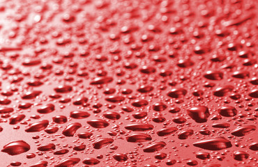 image of red surface with drops close-up