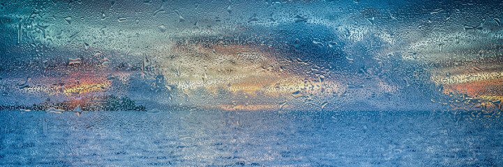 rain drops at colourful sunrise on a window 
