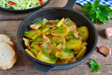 fried potatoes with bacon and green onions in a cast iron skille