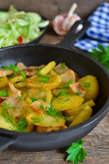 fried potatoes with bacon and green onions in a cast iron skille