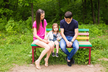 Family sitting on park bench