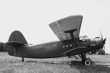 Biplane on the airfield. Side view. Black and white.