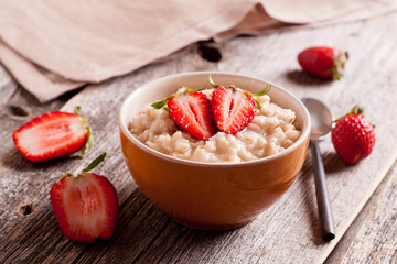 Tasty oatmeal with strawberry on table close-up