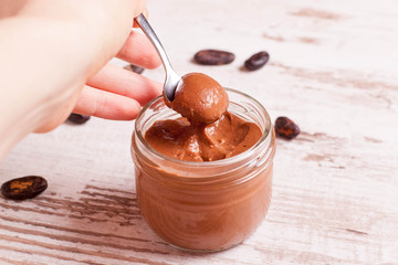 chocolate paste with nuts in a glass jar closeup