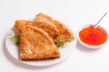 crepes with red caviar on the plate, isolated on white