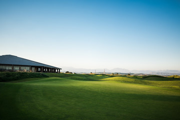 Fototapeta na wymiar Beautiful golf club house with rays of sun at sunset