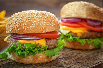 Cheeseburgers on wooden background with copy space 