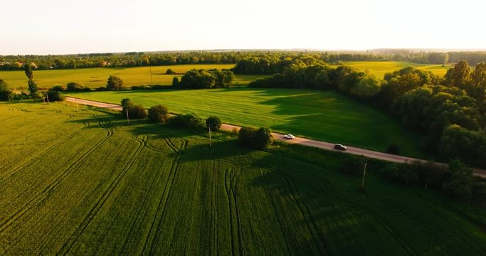 Flight Over a Large Green Field and Road