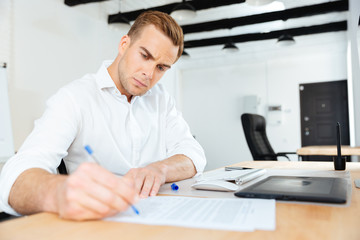 Fototapeta premium Businessman sitting in office and writing