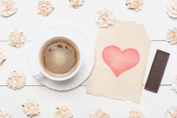 Cup of coffee and vintage paper sheet with heart symbol and rose