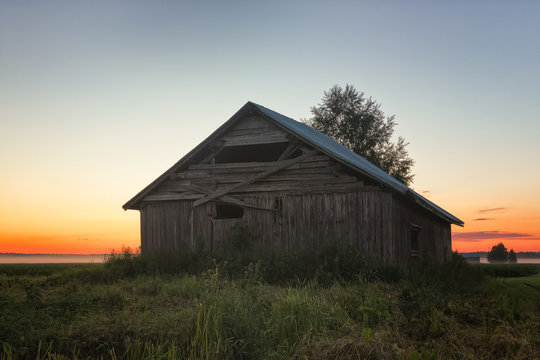 Sunset Behind A Barn And A Birch
