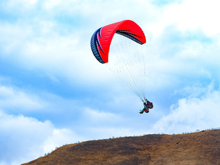 flying paraglider in the sky and the hill