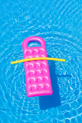 Pink air bed floating on a swimming pool