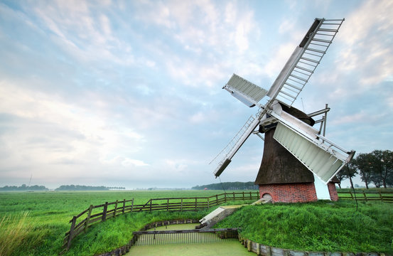 Dutch windmill during cloudy summer morning