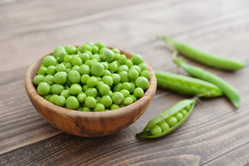 Green peas in wooden bowl