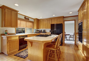 Kitchen room with wooden cabinets, light tone hardwood floor