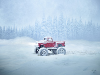 Miniature red monster truck in winter storm