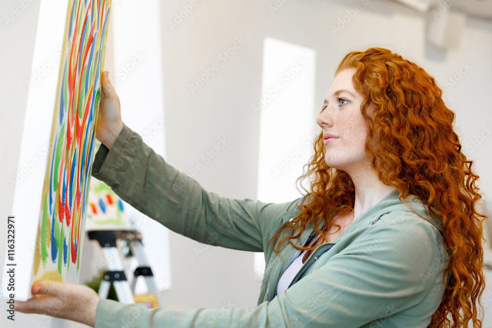 Wall mural young caucasian woman standing in art gallery front of paintings