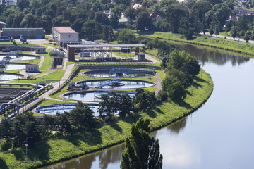 Aerial view of river meandering around sewage water treatment plant