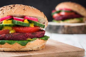Veggie beet burger on white table and black slate background

