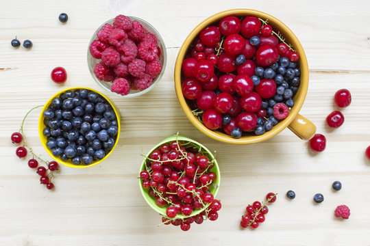 Fresh summer meal background: mix berries on a wooden table top view.