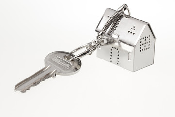 key with keychain in the form of a silver-colored house on a white background