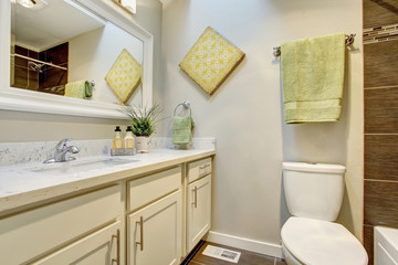 Bathroom interior with white cabinets, tile floor