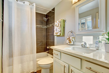 Bathroom interior with white cabinets, tile floor