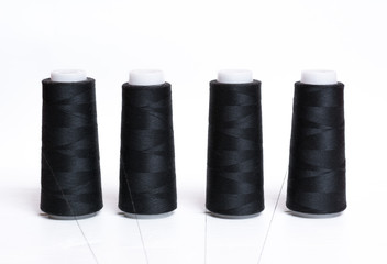 Black bobbin thread on white wooden table
