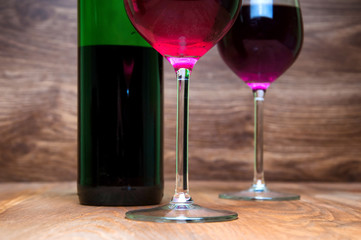 Wine glass and bottle on a wooden background
