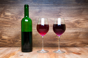 Wine glass and bottle on a wooden background