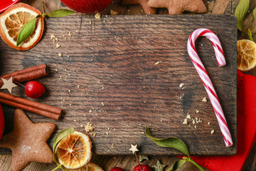 Candy cane and other christmas sweets on wooden background