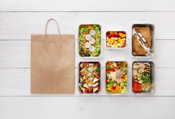 Healthy food take away in boxes, top view at wood