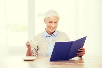 Fototapeta na wymiar happy smiling senior woman reading book at home