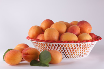Apricots in a bowl and a few apricots beside it